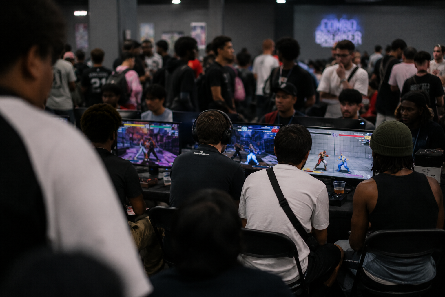 Players gathered around fighting-game freeplay setups.